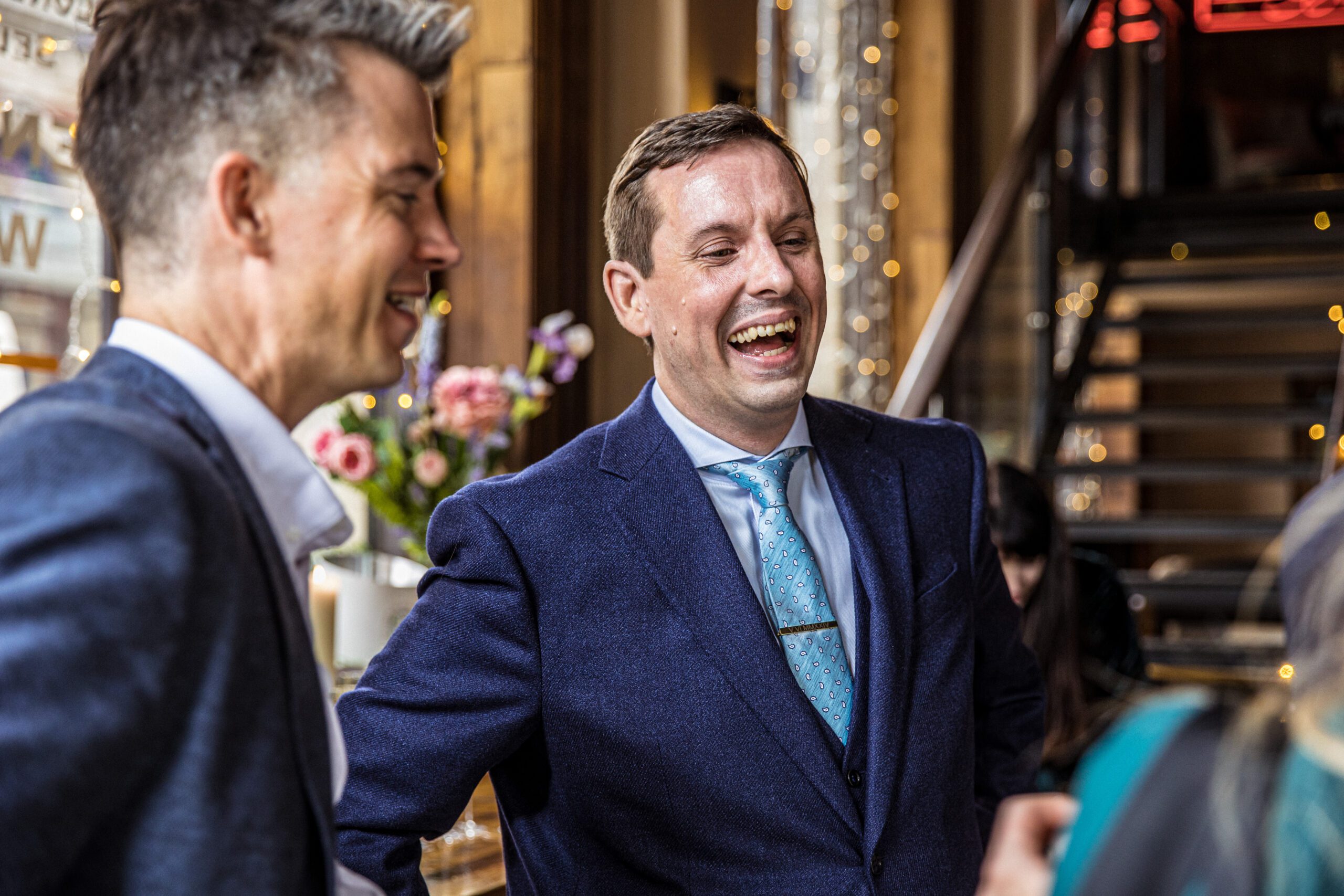 The groom laughs with guests at his wedding at Balfour St Barts