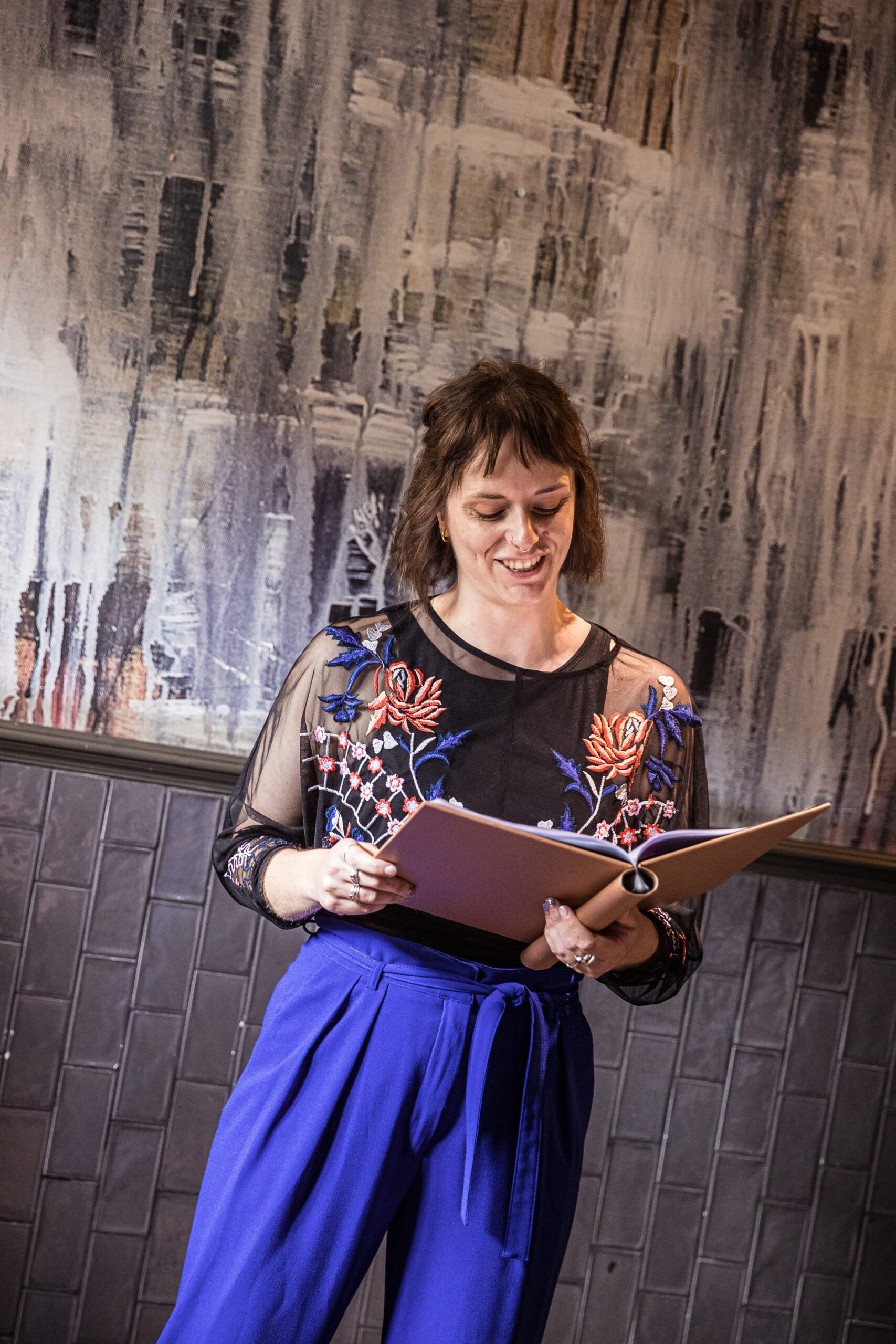 A wedding celebrant reads from her book as she hosts the wedding ceremony at Balfour St Barts