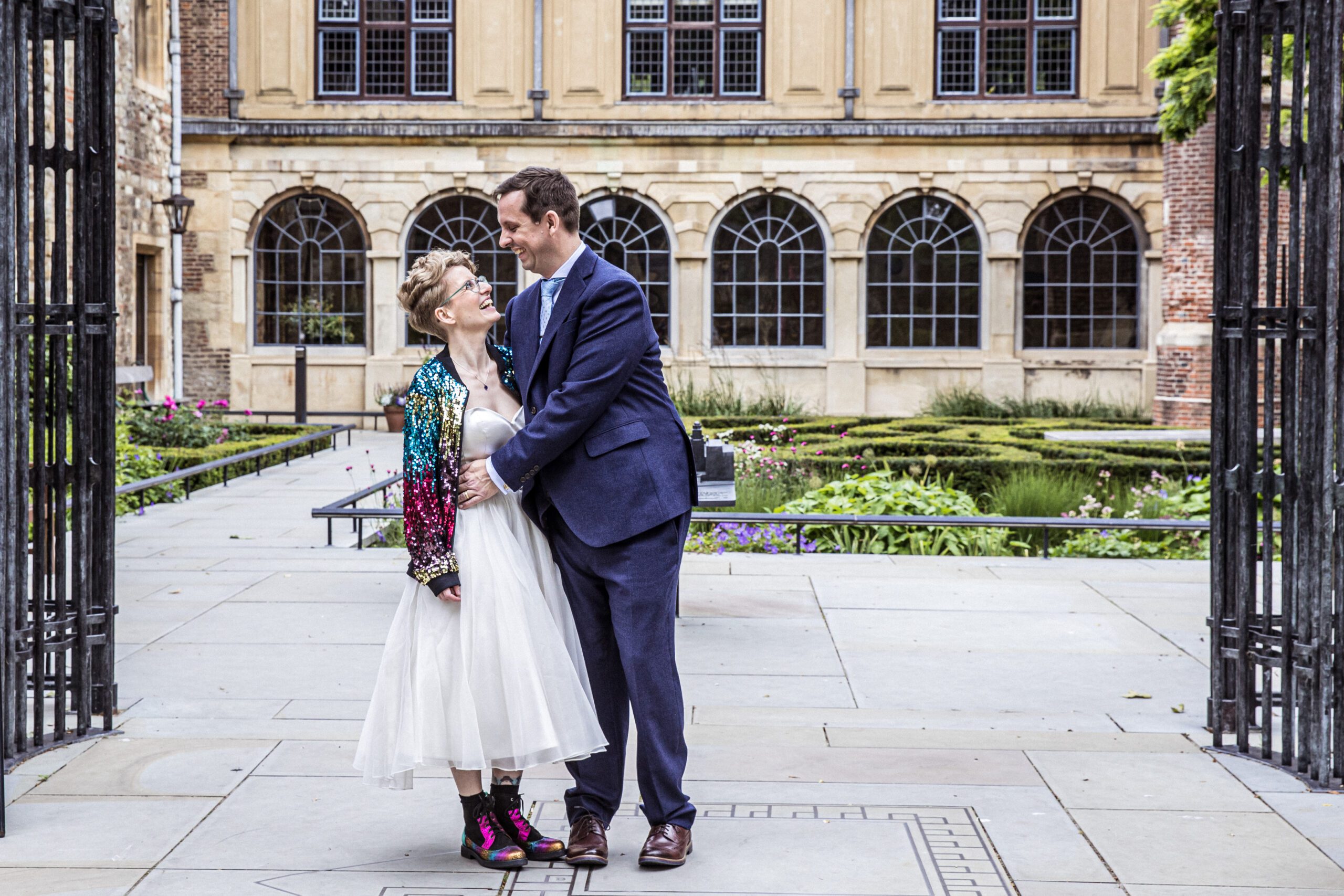 A bride and groom pose outside Charterhouse gardens in London