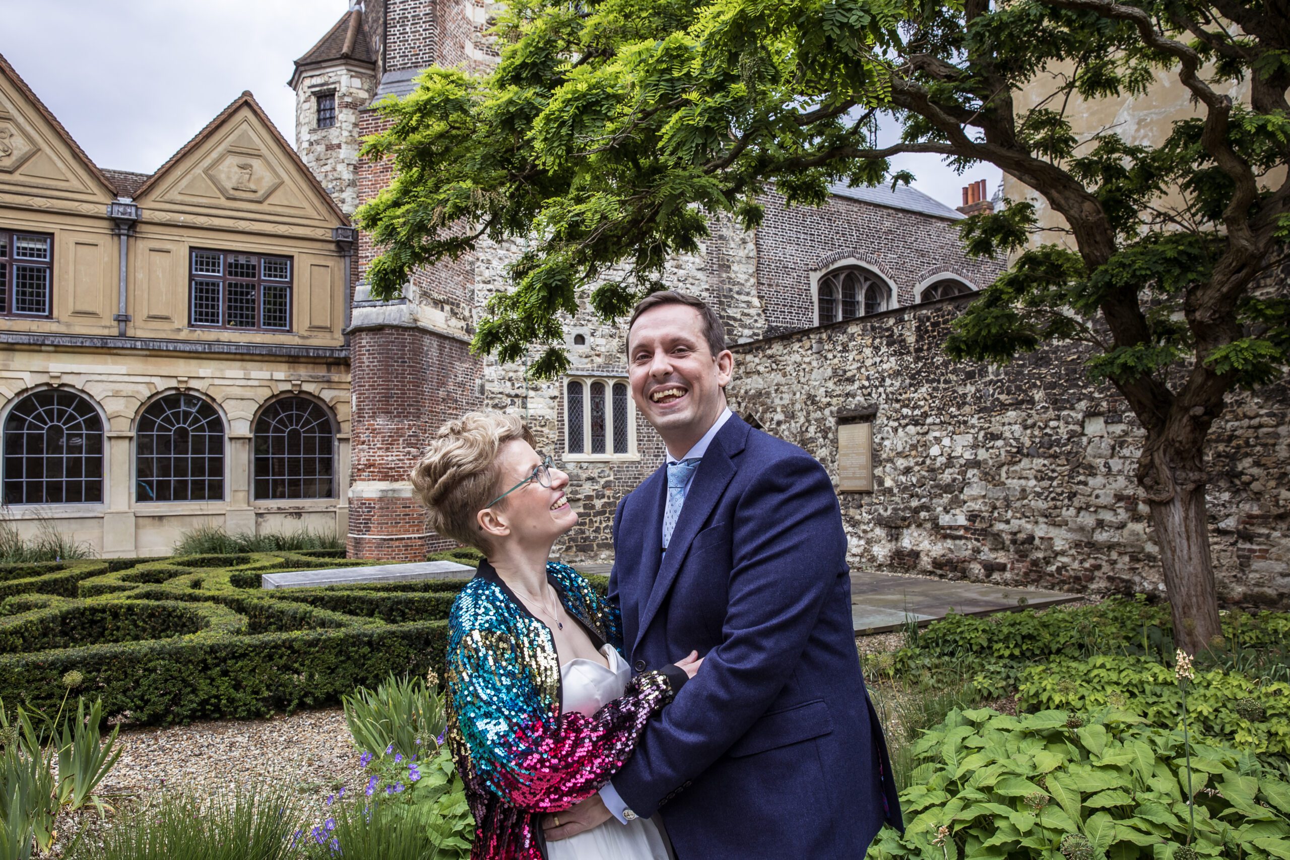 A bride looks at her groom as he smiles to the camera at Charterhouse in Clerkenwell
