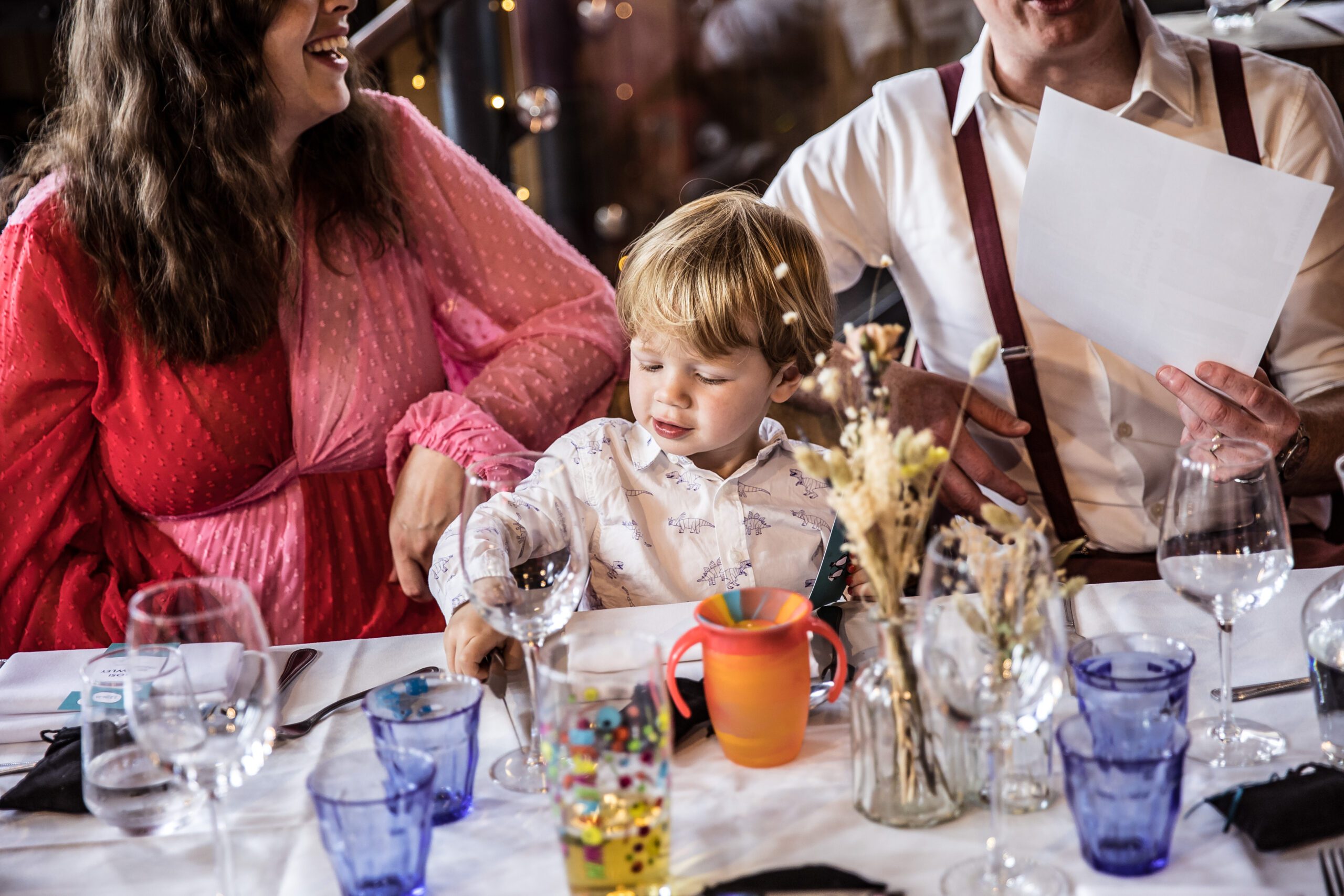 A small guest is seated with his parents at Balfour St Barts London wedding.