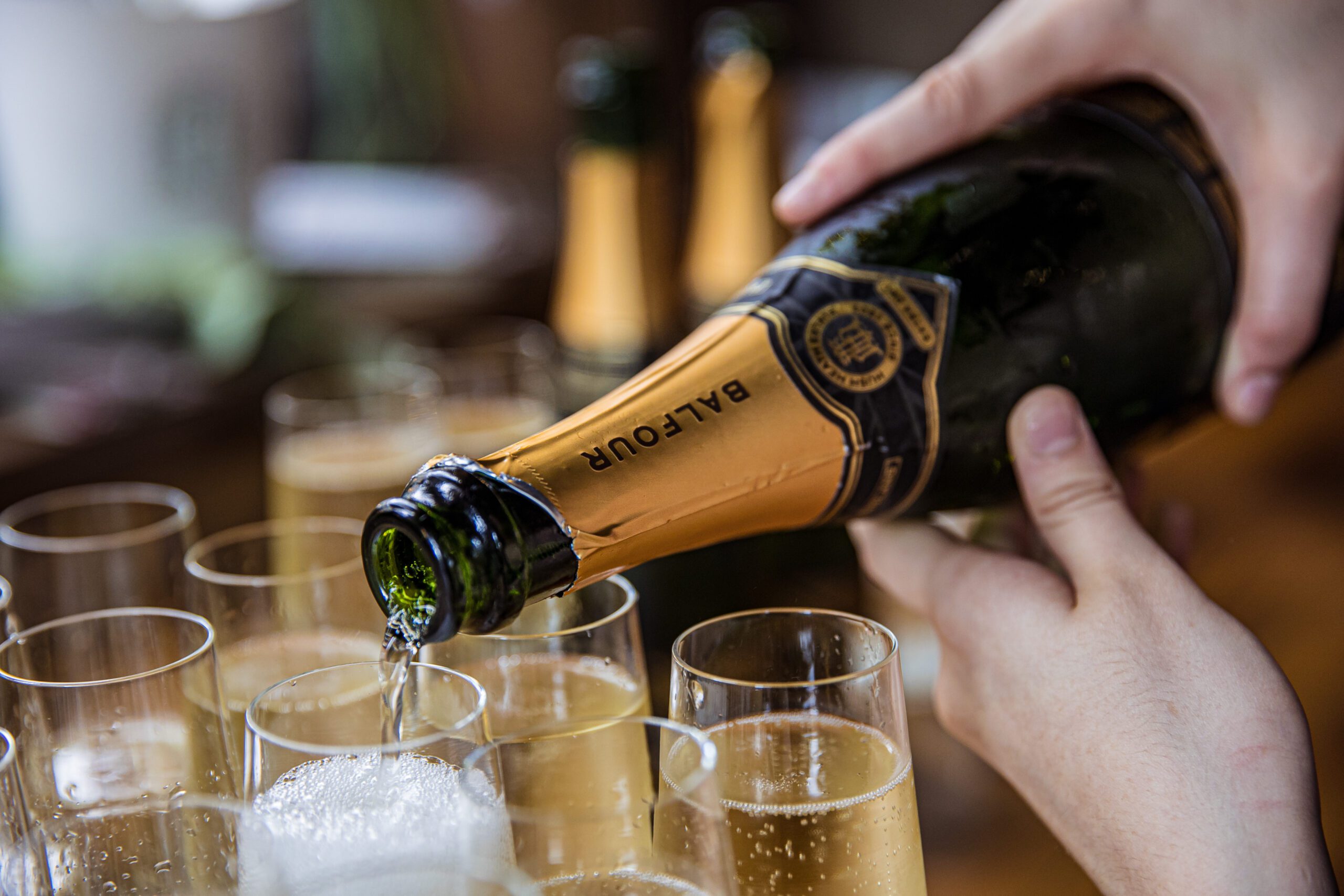 A champagne bottle being poured with Balfour St Parts written on it