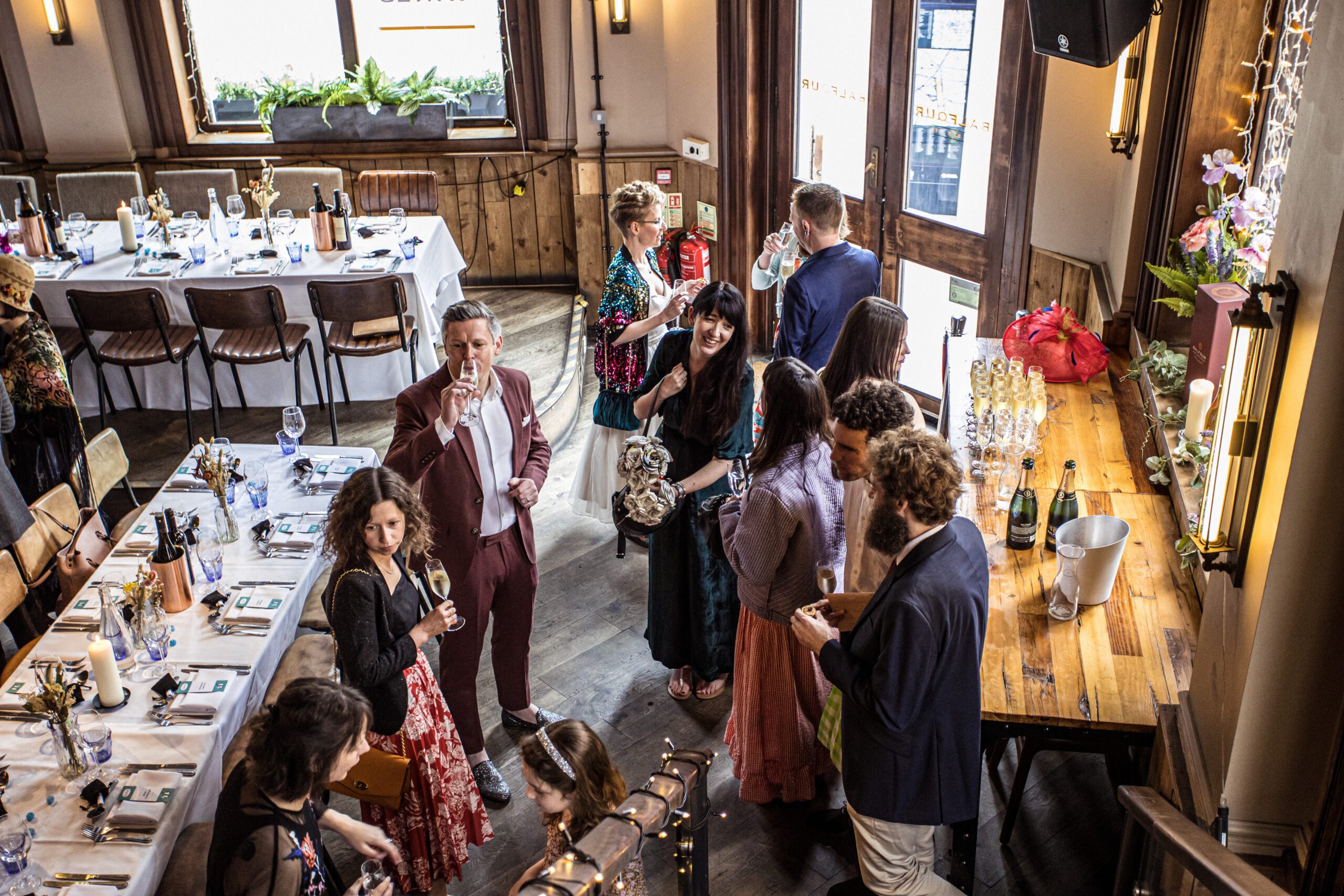 A lady in a group of wedding guests laughs at Balfour st parts wedding.