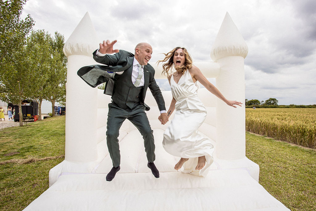 a wedding cake made of cheese being cut by bride and groom in hertfordshire