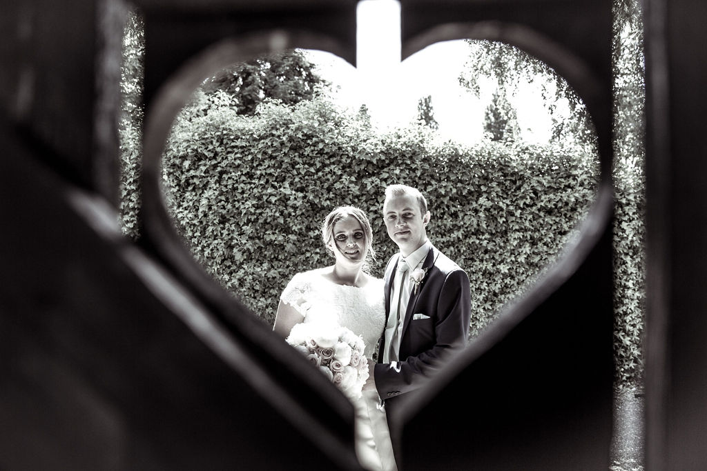 new husband and wife at their garden wedding in hertfordshire. photographer captures a smile between happy couple with summer flowers